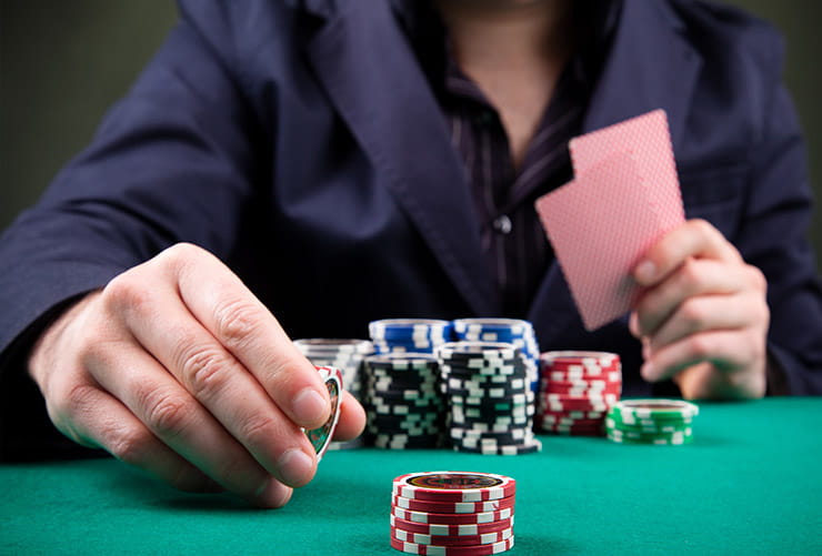 Man Playing and Holding Casino Chips and Cards