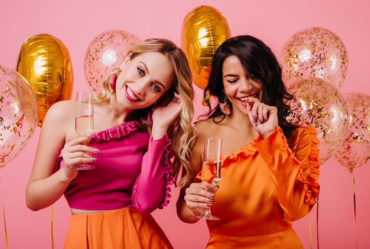 Two Ladies Celebrating with Baloons and Glasses