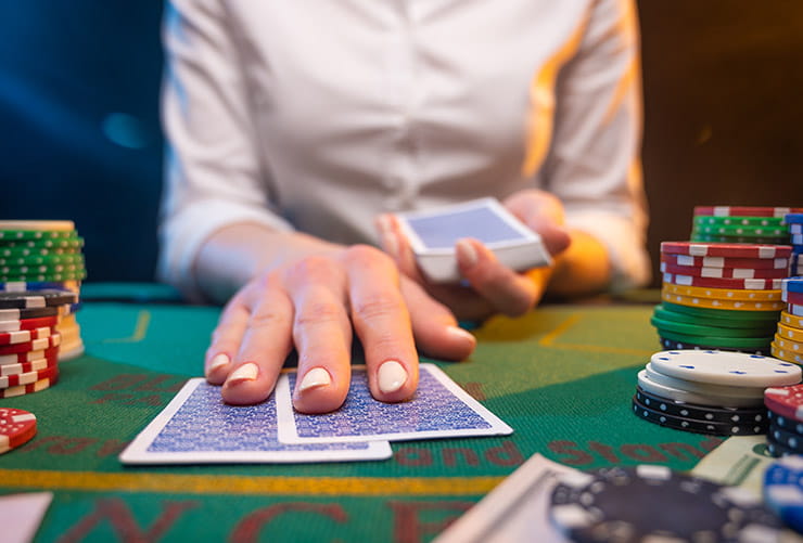 Croupier Holding Two Cards on a Casino Table