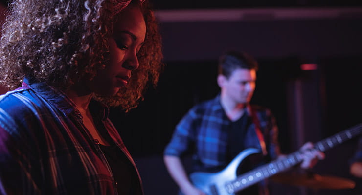 A Woman and a Man Playing on a Guitar